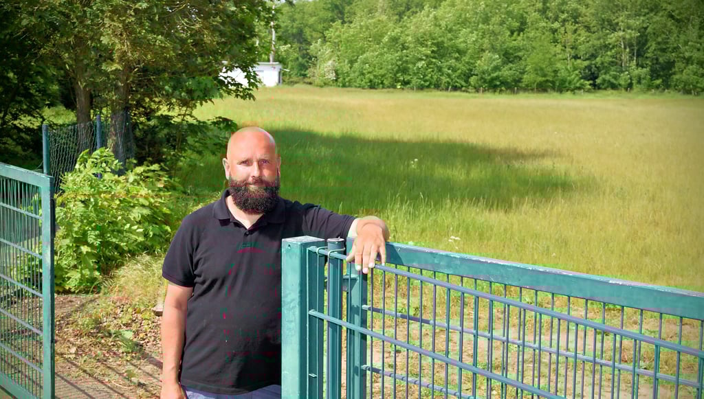 Tobias Just am Eingang des ehemaligen Freibadgeländes: Wo in diesem Moment hohes Gras stand, wird bald „Kleene Pfingsten“ gefeiert.
