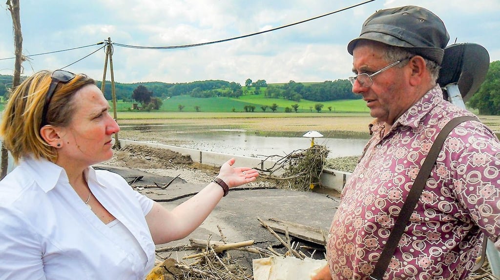 Hochwasser 2013: Die Bürgermeisterin Manuela Hartung spricht in Wetterzeube mit Bauer Werner Hoppe.