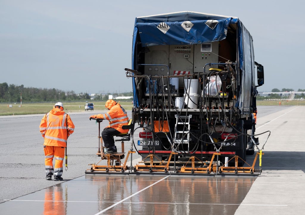 Eine spezielle Flüssig-Grundierung bringen Arbeiter mit einem Spezialfahrzeug auf der Landebahn Nordwest auf dem Flughafen in Frankfurt an. Am Frankfurter Flughafen hat der Betreiber Fraport die frisch sanierte Landebahn Nordwest nach wenigen Betriebsstunden wieder gesperrt.