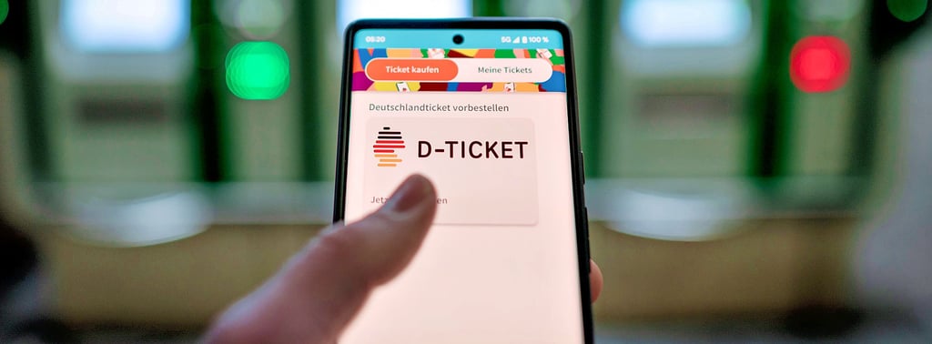 Ein Mann hält ein Mobiltelefon in der Hand, mit dem das 49-Euro-Ticket, auch „D-Ticket“ genannt, über eine App gekauft und genutzt werden kann.