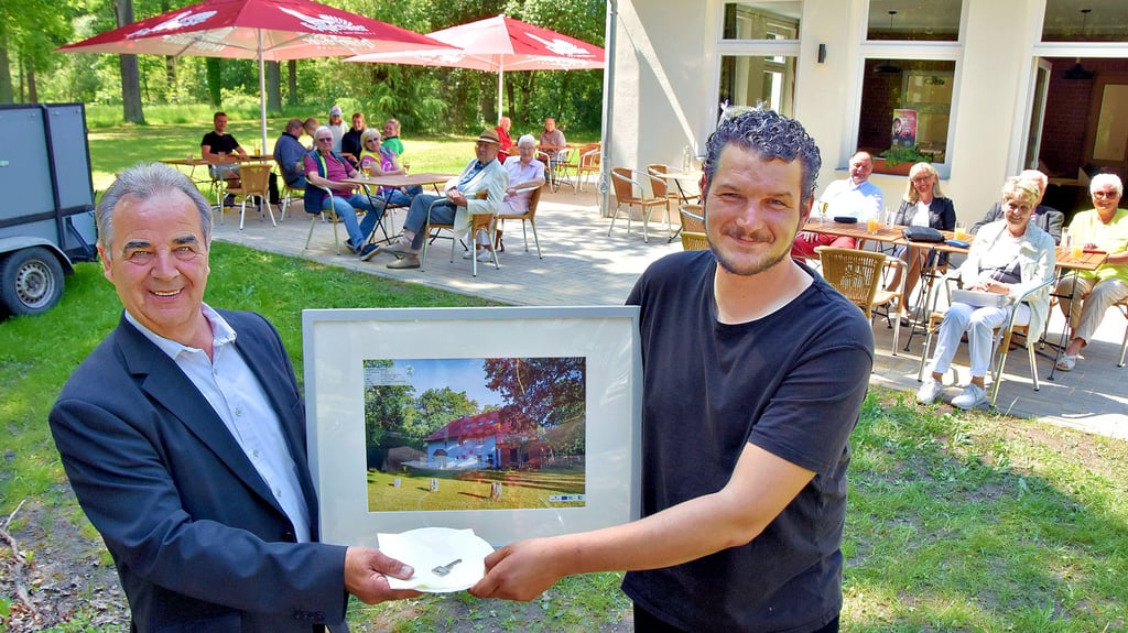 Ein eingerahmtes Foto vom Grieps und den Schlüssel für die Gaststätte überreicht Calvördes Bürgermeister Volkmar Schliephake bei der offiziellen Geschäftseröffnung an den neuen Pächter Maik Schollbach.