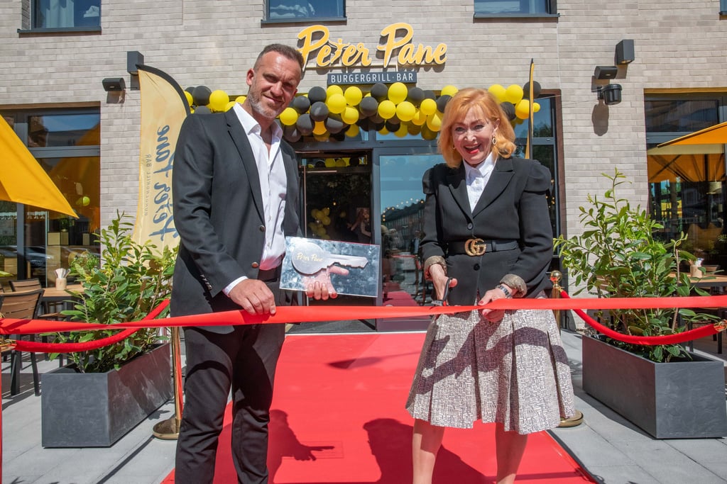 Betreiber Stephan Trappe und Heidelinde Gerhold, Ehefrau von Getec-Investor Karl Gerhold, beim Banddurchschnitt. Dessau hat mit der Burgergrill-Bar Peter Pane nun eine neue kulinarische Adresse.