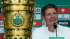 Oliver Glasner, Cheftrainer von Eintracht Frankfurt, lächelt während der Pressekonferenz hinter dem Pokal.