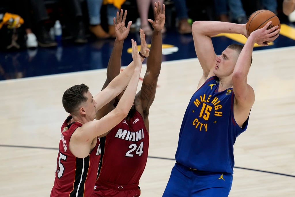 Denvers Nikola Jokic (r) wirft über Miamis Duncan Robinson (l) und Haywood Highsmith.
