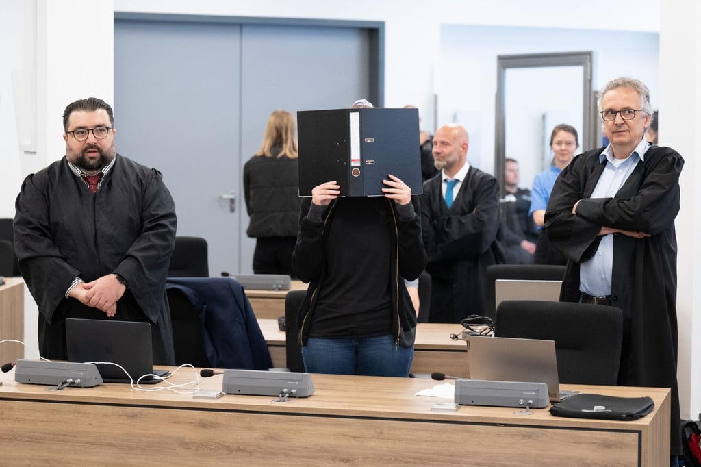 Die Angeklagte (M) steht bei der Fortsetzung des Prozesses im OLG Dresden im Verhandlungssaal.