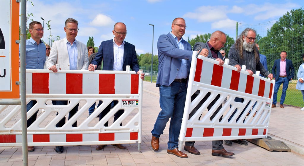 Stadtrat Stefan Helmholz (von rechts), Oberbürgermeister Frank Ruch, Stadtrat Sebastian Petrusch, Eiko Fliege (Bäder GmbH) sowie Vertreter beteiligter Bauunternehmen hoben die Sperrung der Lindenstraße symbolisch auf.