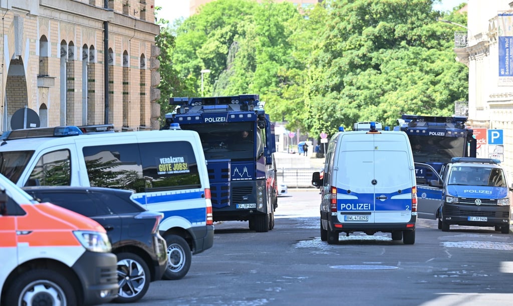 Wasserwerfer der Polizei stehen an der Polizeidirektion in Leipzig.
