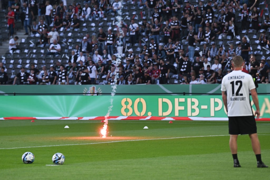 Pyrotechnik fliegt während des Aufwärmens auf den Rasen.