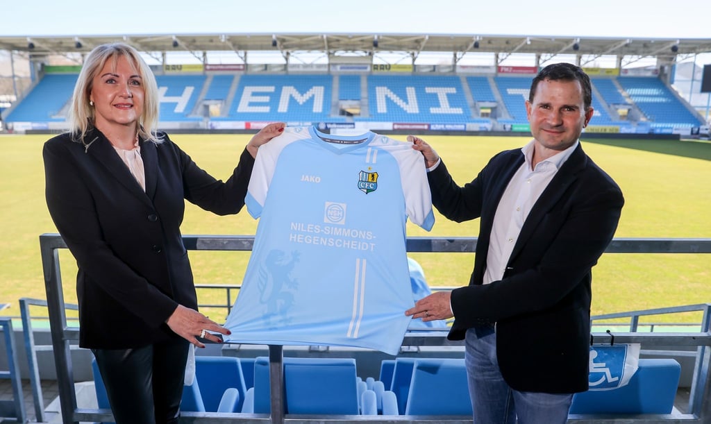 Romy Polster und Marc Arnold halten bei ihrem Antritt symbolisch ein Fußballtrikot im Stadion an der Gellertstraße.