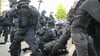 Bei Protesten gegen das Urteil gegen Lina E. in Leipzig rangeln Polizisten und ein Demonstrant auf dem Boden.