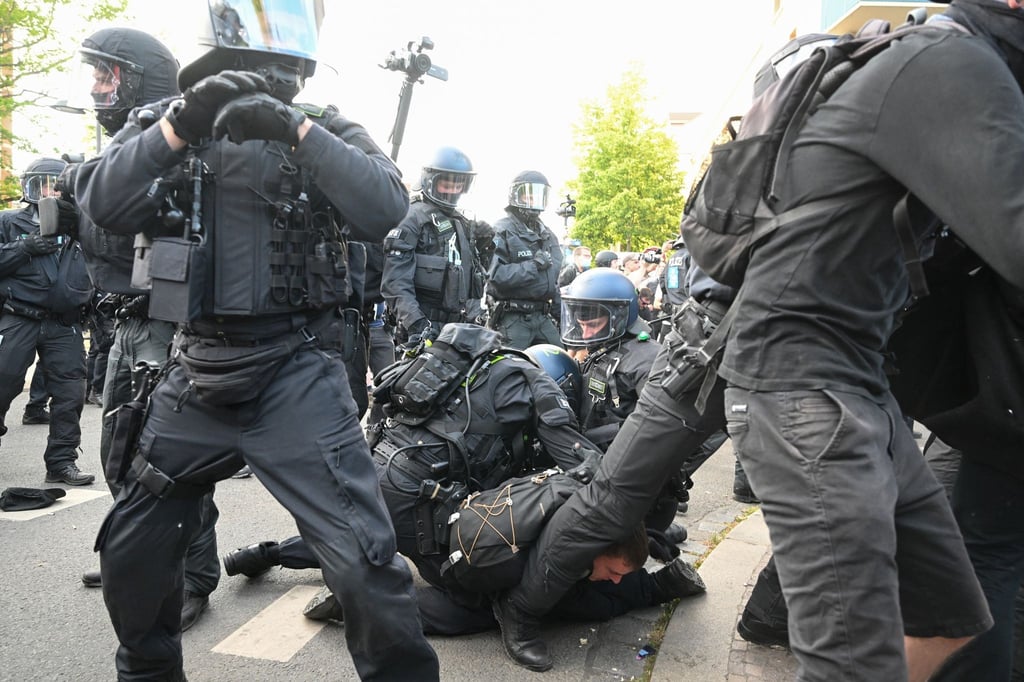Bei Protesten gegen das Urteil gegen Lina E. in Leipzig rangeln Polizisten und ein Demonstrant auf dem Boden.