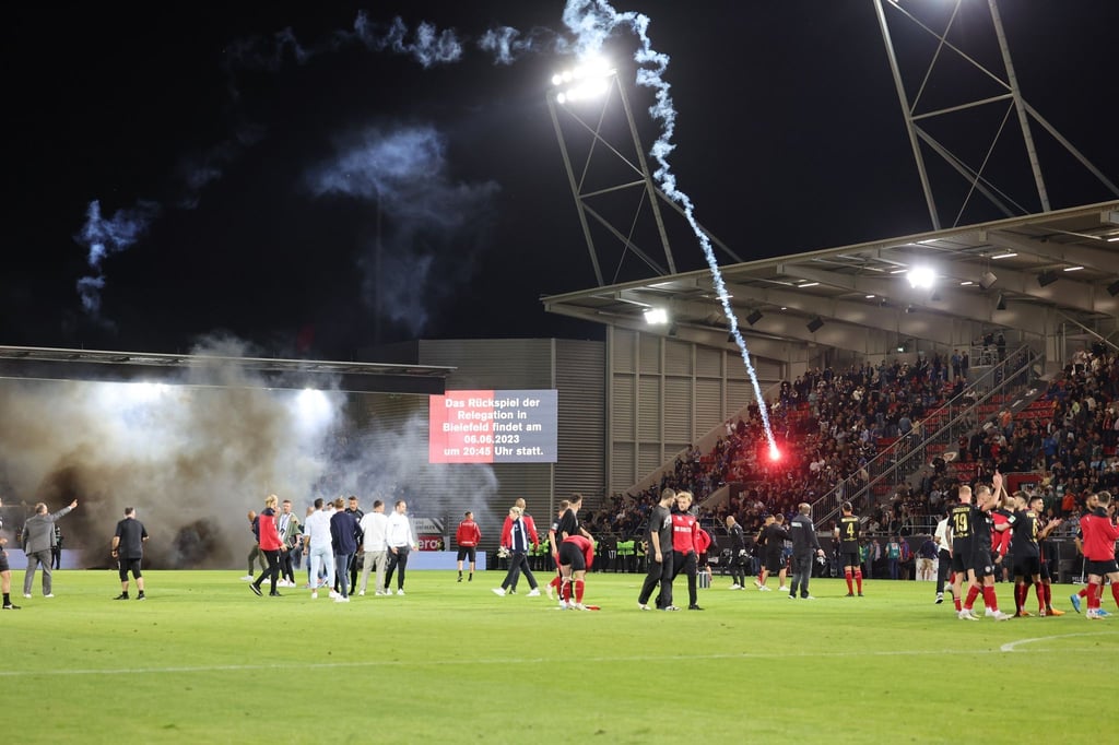 Schlussszene beim Relegationshinspiel, Raketen fliegen auf das Spielfeld.
