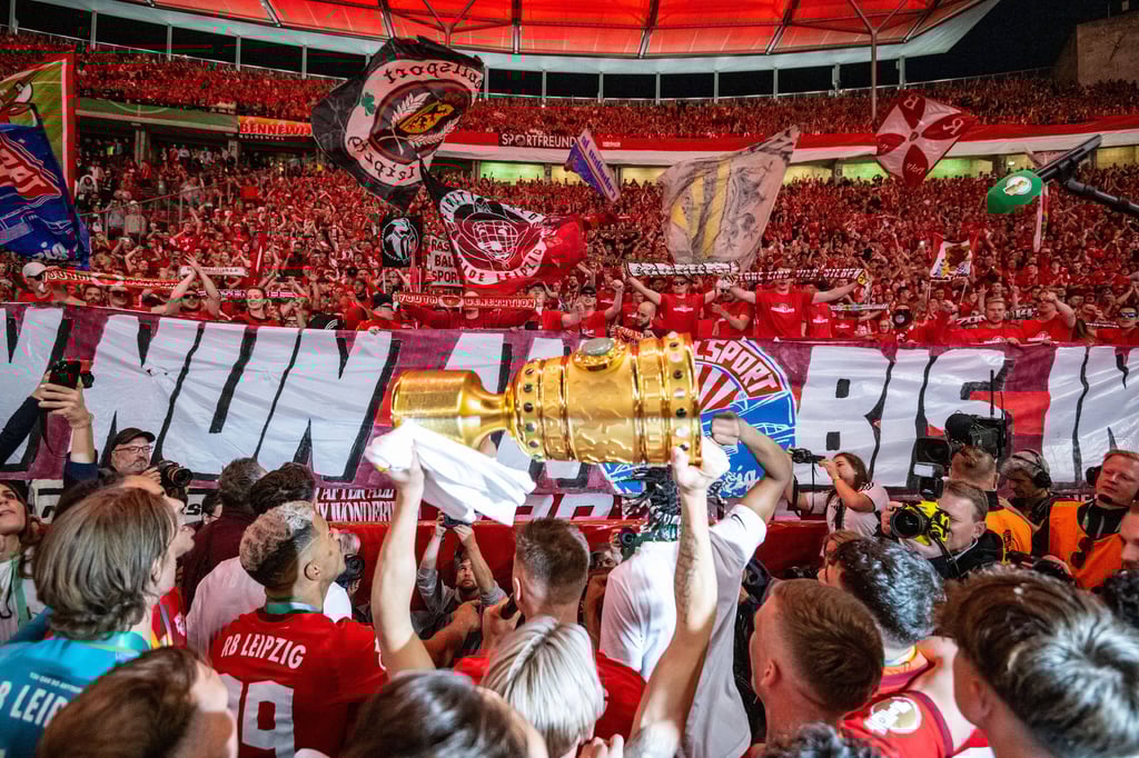 Mit dem Pokal in der Hand feiern die RB-Spieler nach der Siegerehrung vor den Leipziger Fans im Olympiastadion in Berlin.
