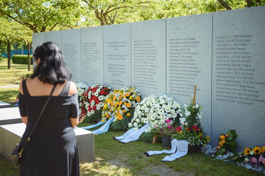 Eine Frau steht am 25. Jahrestag vor der Gedenktafel der Opfer des ICE-Unglücks von Eschede.