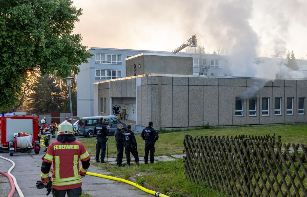 Die Feuerwehr löscht einen Brand in einer Flüchtlingsunterkunft.
