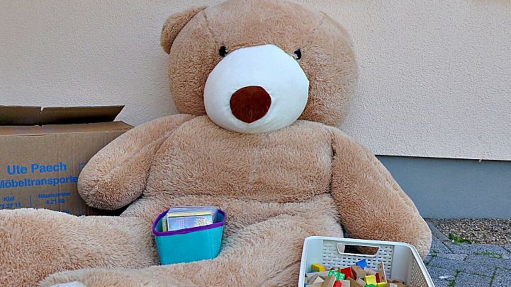Ein lebensgroßer Teddy samt Spielzeug liegt vor einer Kita in Stendal.