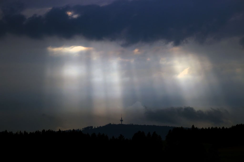 Sonnenstrahlen dringen durch Wolkenlücken.