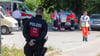 Rettungskräfte arbeiten nach dem Brand in einer Flüchtlingsunterkunft.