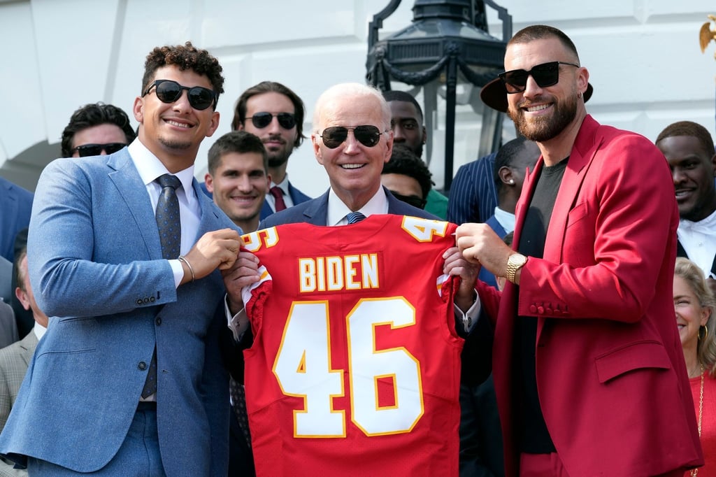 Kansas City Chiefs-Quarterback Patrick Mahomes und Kansas City Chiefs-Tight End Travis Kelce überreichen Präsident Joe Biden ein Trikot.