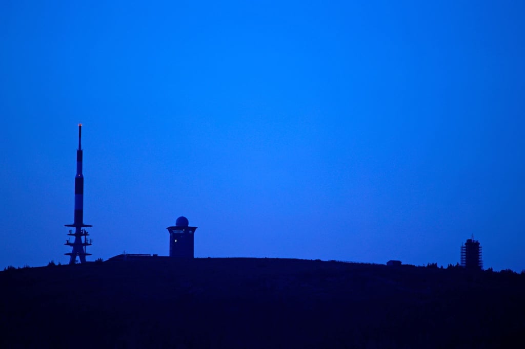 Im Licht der Abenddämmerung steht der Brocken am Horizont.