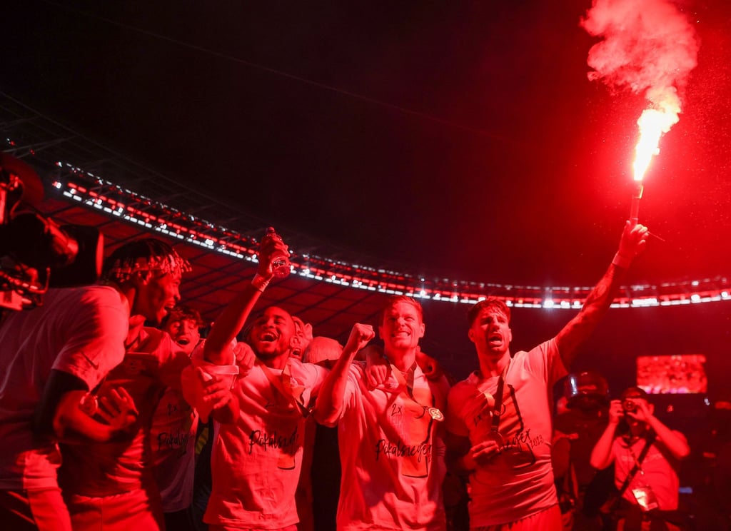 Leipzigs Dominik Szoboszlai (r) feiert den RB-Pokalsieg mit einer Pyro-Fackel.