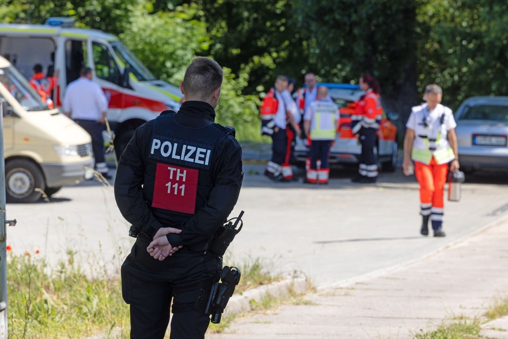 Rettungskräfte arbeiten nach dem Brand in einer Flüchtlingsunterkunft.