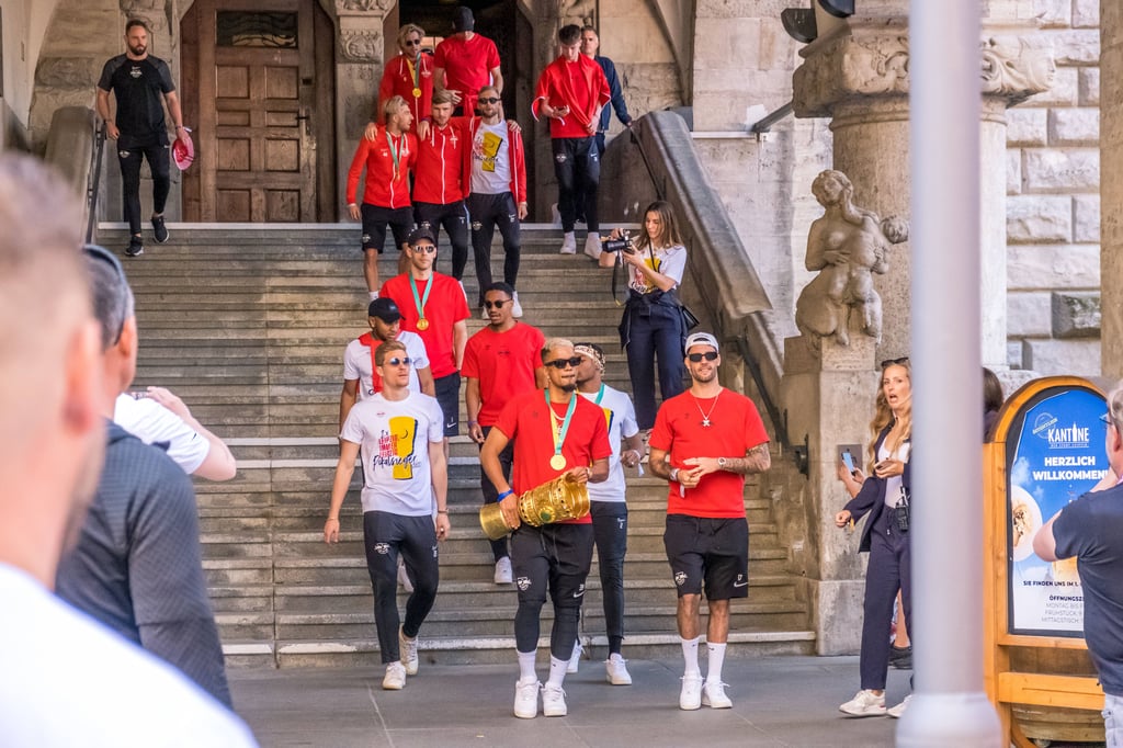 Die Mannschaft (vorne mit Pokal: Benny Henrichs) verlässt das Rathaus.
