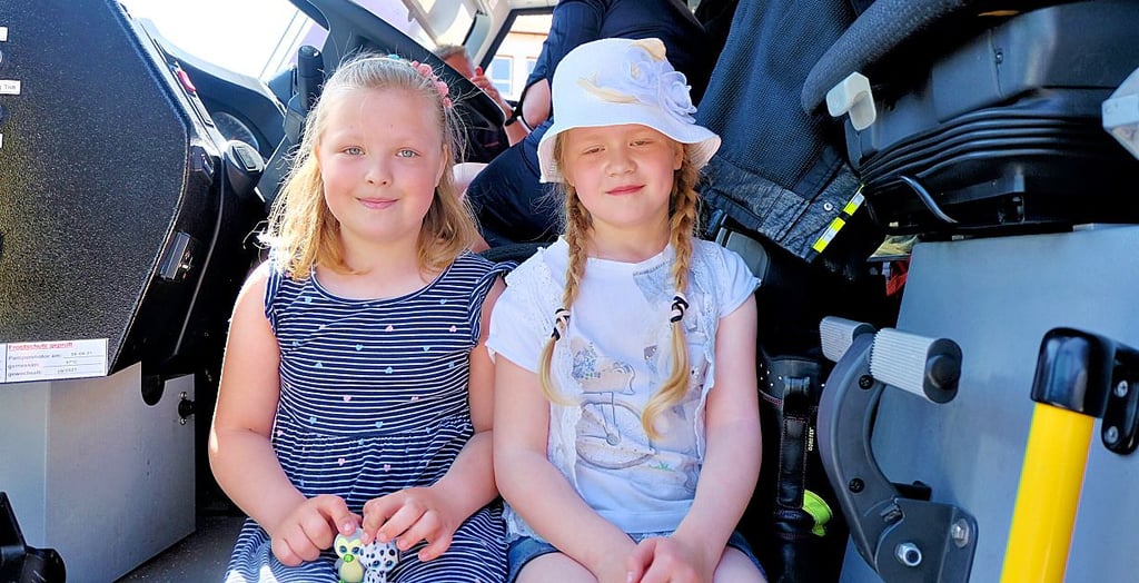 Die siebenjährige Cecilia (links) und ihre Freundin Lina finden es toll, im großen Löschfahrzeug der Bundeswehr Holzdorf zu sitzen.