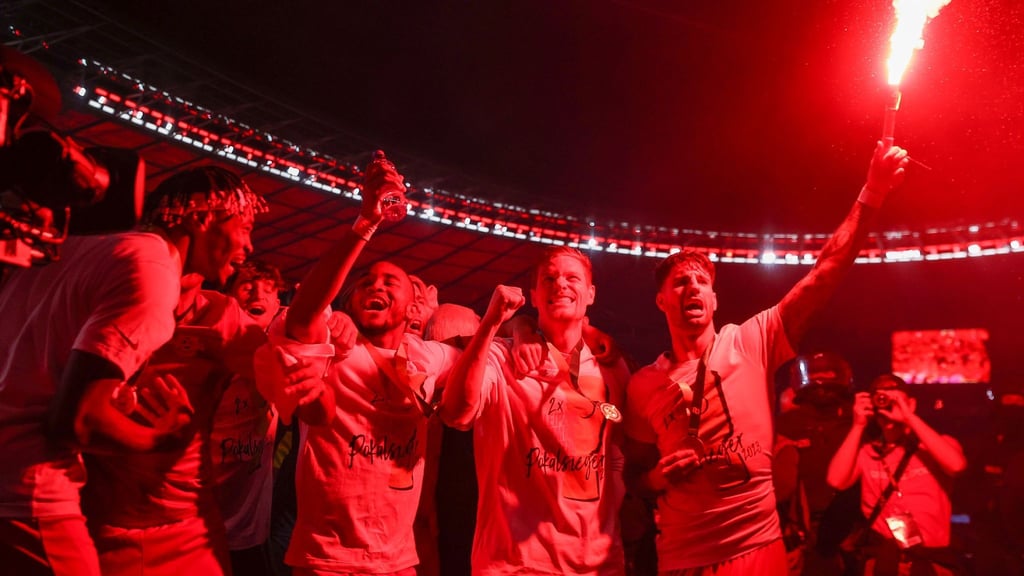 Leipzigs Dominik Szoboszlai (r) feiert den RB-Pokalsieg mit einer Pyro-Fackel.