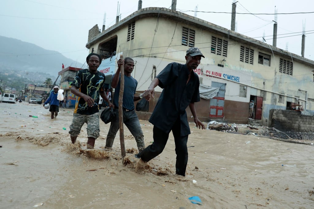 Bewohner waten über eine überschwemmte Straße nach einem starken Regen in Port-au-Prince.