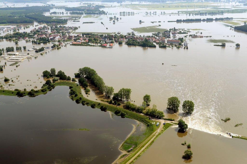 Ein Deichbruch (unten r) überflutet das Dorf Fischbeck. Am 10. Juni 2013 durchbrach das Juni-Hochwasser den Deich bei Fischbeck und flutete mehr als 150 Quadratkilometer.