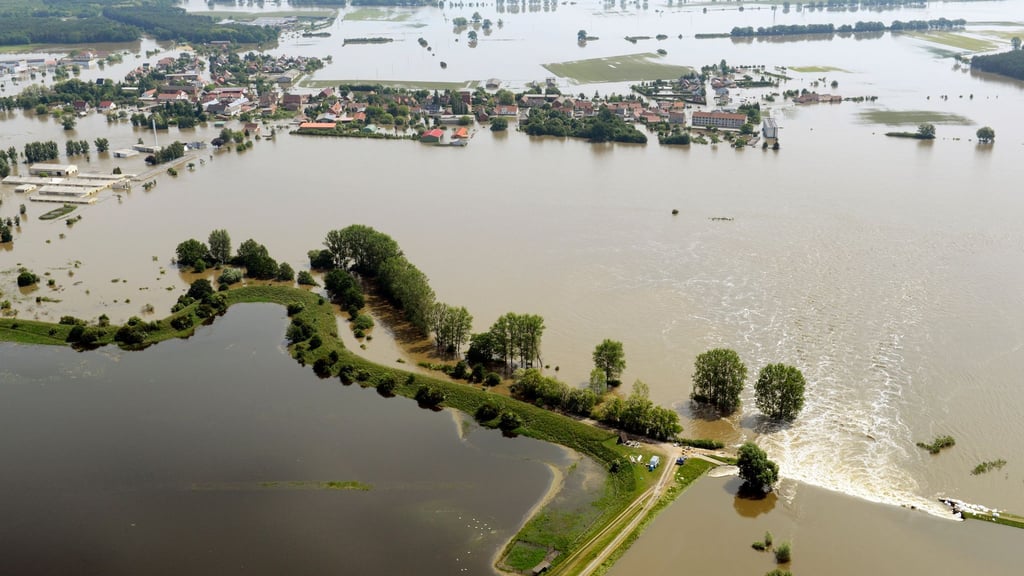 Ein Deichbruch (unten r) überflutet das Dorf Fischbeck. Am 10. Juni 2013 durchbrach das Juni-Hochwasser den Deich bei Fischbeck und flutete mehr als 150 Quadratkilometer.