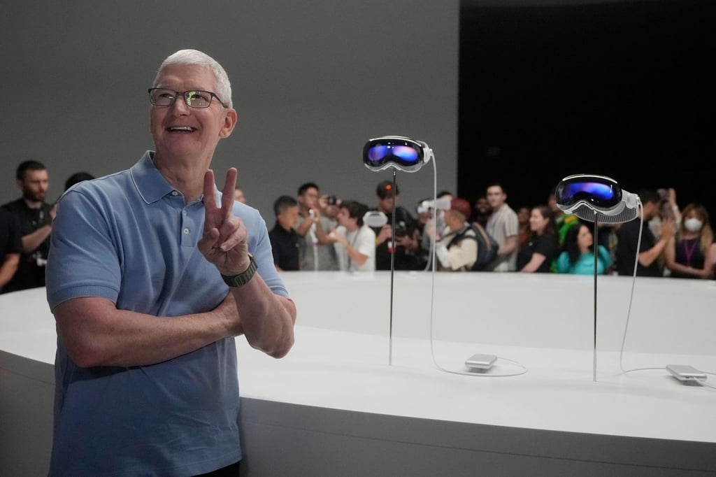 Apple-CEO Tim Cook posiert neben den neuen Vision Pro Headsets auf dem Firmencampus in Cupertino.