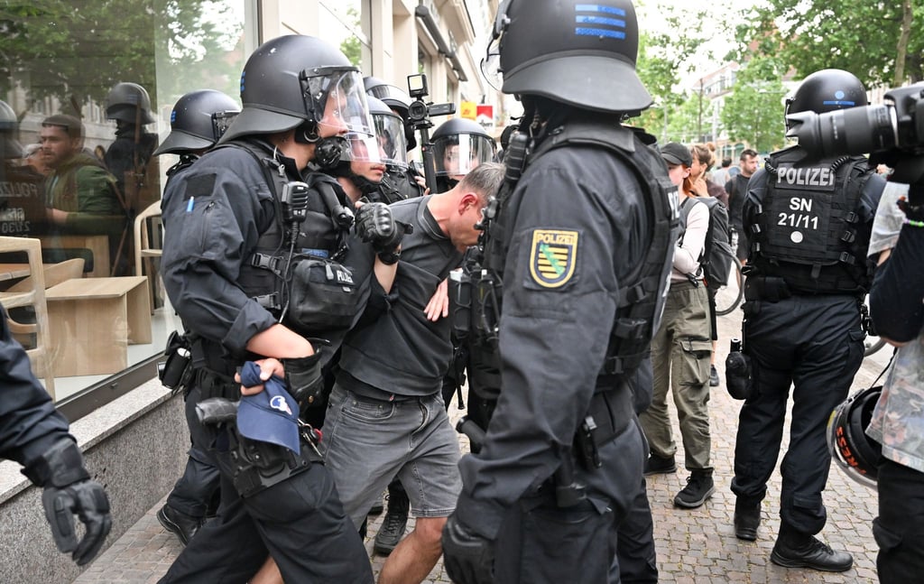 Polizisten halten einen Teilnehmer aus einer Demonstration in Leipzig fest.