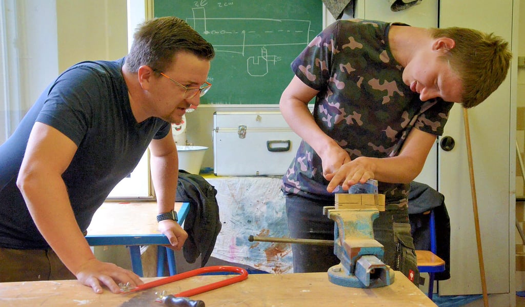 Anleiter Janek Schwigon (links) gibt dem 17-jährigen Justin Tipps bei der Herstellung eines Löffels. Justin ist seit April im Projekt „WERKstattSCHULE“ am Standort in Staßfurt.