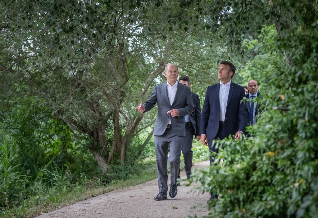 Bundeskanzler Olaf Scholz (SPD, l) geht mit Emmanuel Macron, Präsident von Frankreich, zu einem gemeinsamen Abendessen.