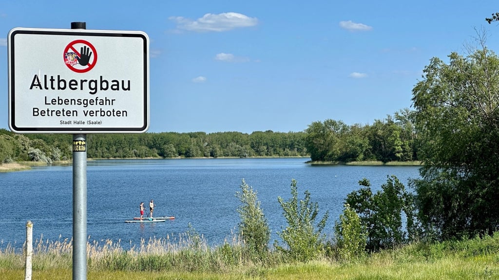Am Ufer des Hufeisensees in Halle warnen Schilder vor unsicheren Böschungen. Doch es gibt Bereiche, in denen kein Bergbaurisisko besteht.