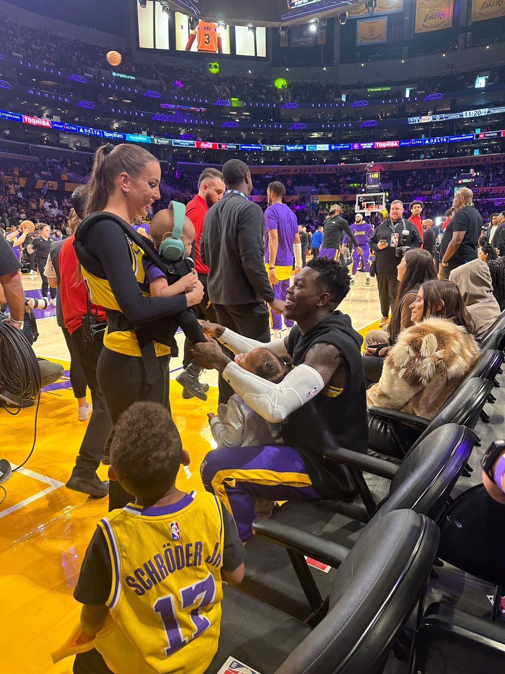 NBA-Profi Dennis Schröder (r) spricht vor dem Spiel mit seiner Frau Ellen Schröder und seinen drei Kindern.