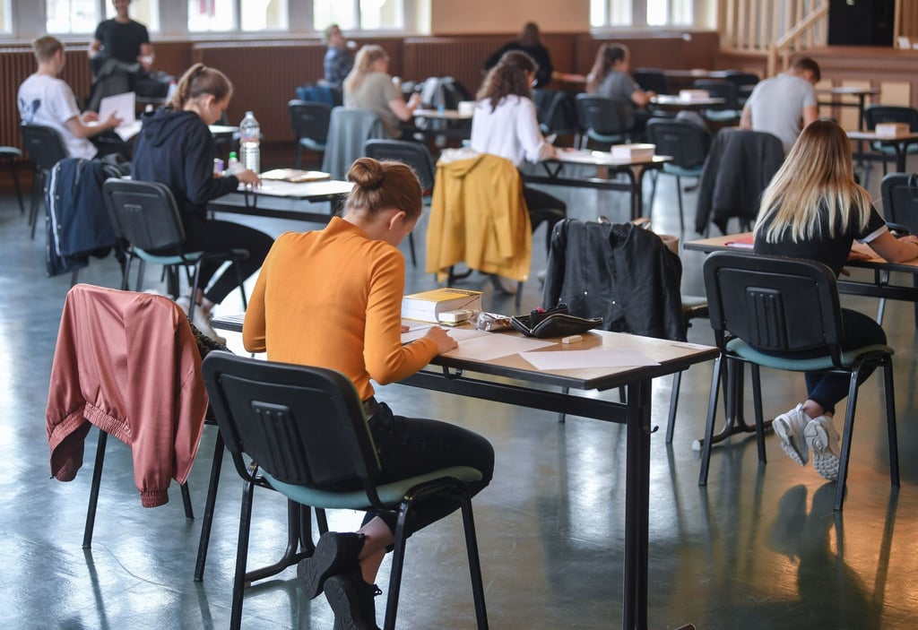 Schüler sitzen in einer Aula in der Vorbereitungszeit für ihre Abschlussprüfung.