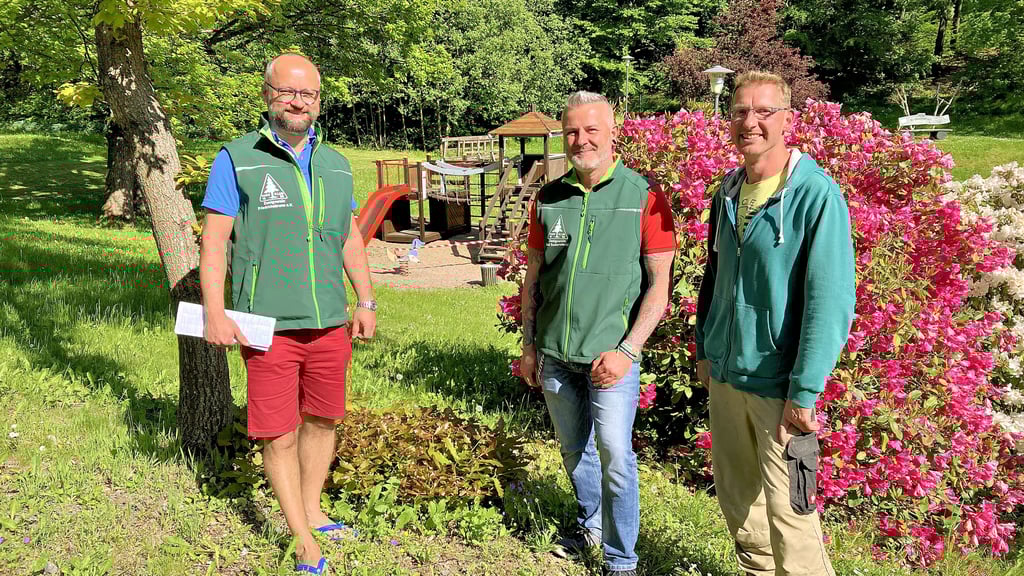 Mit viel Grün und blühenden Pflanzen ist der Kurpark herausgeputzt. Mario Kriebel (Zweigverein Friedrichsbrunn, von links), Stephan Krimmling (Bad Suderode) und Thomas Jung (Friedrichsbrunn) freuen sich, dass der Spielplatz (Hintergrund) rechtzeitig zum Naturschutztag fertig wurde.