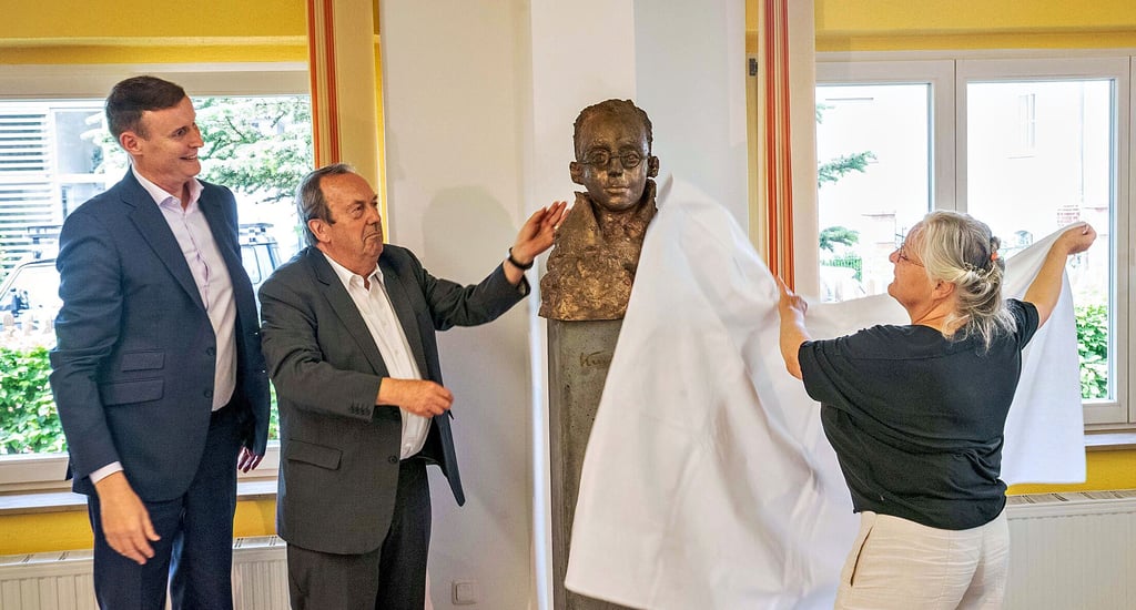 Der „Goldjunge“, der junge Kurt Weill, wird im Saal der Musikschule feierlich enthüllt von Bildhauerin von Anna Franziska Schwarzbach sowie Joachim Landgraf und Christoph Göring vom Förderverein (v.r.n.l.).
