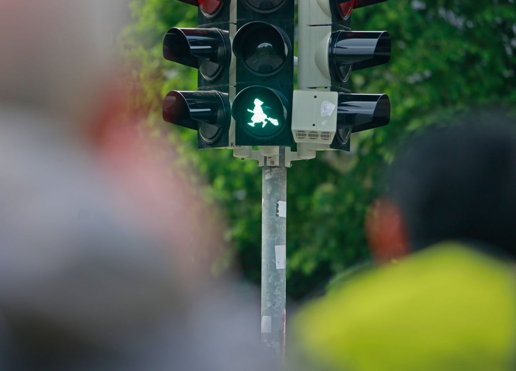 Blick auf eine Ampelanlage mit einer Hexe.