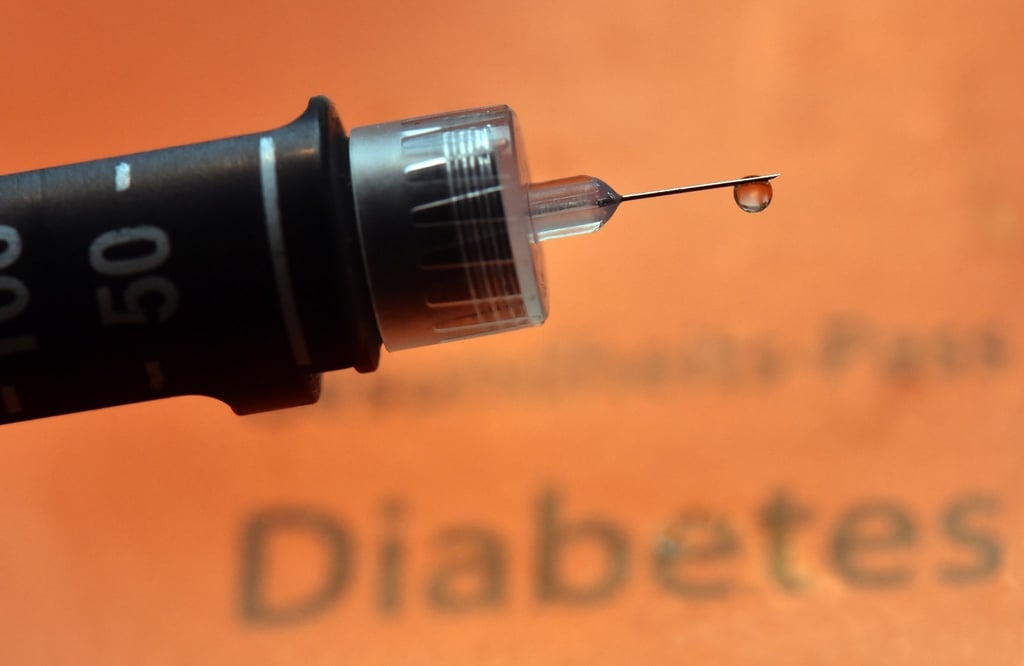 Ein Tropfen Insulin hängt an der Nadel einer wiederverwendbaren Spritze, einem sogenannten Pen, für Diabetiker.