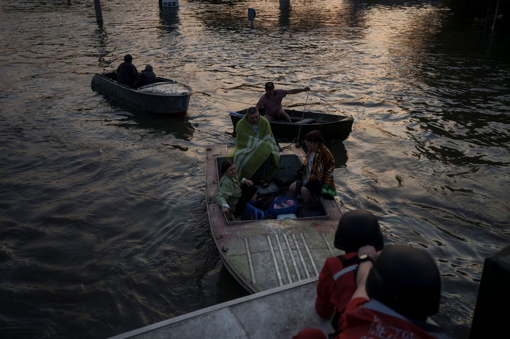 Rettungskräfte versuchen, Boote mit Bewohnern abzuschleppen.