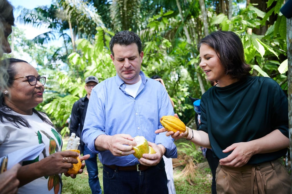 Außenministerin Annalena Baerbock und Arbeitsminister Hubertus Heil mit Kakaofrüchten, während sie sich im Regenwald auf der Insel Combu (Ilha do Combu) bei Belem in Brasilien mit weiblichen Vertretern von örtlichen Kakao-Kooperativen und Frauenorganisationen treffen.
