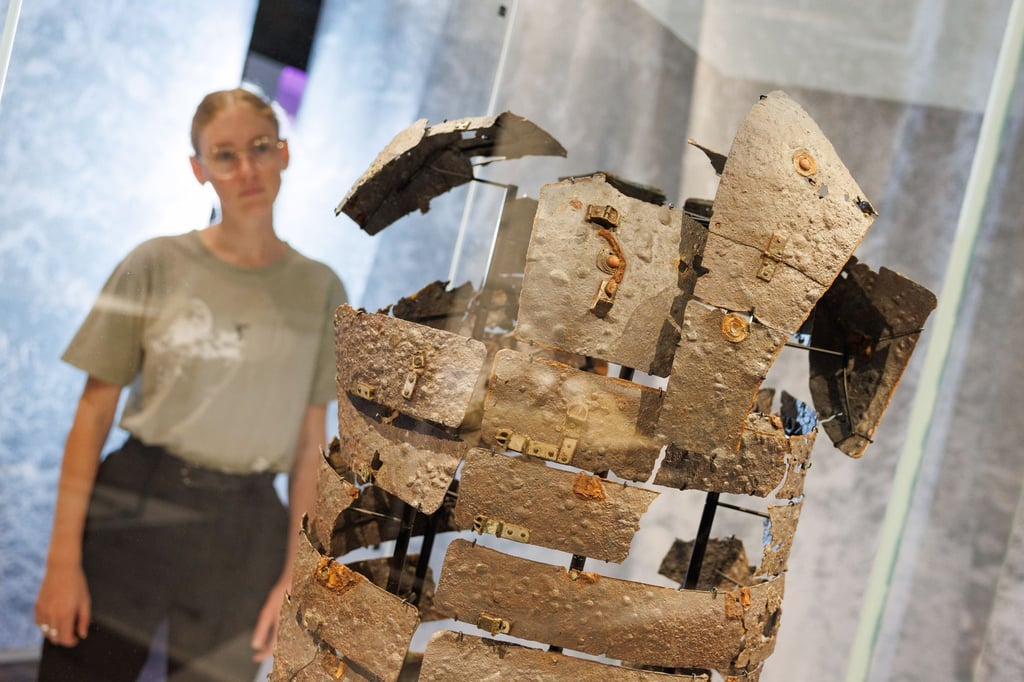 Ausstellungsassistentin Lea Engel blickt auf einen römischen Schienenpanzer (9 n. Chr.).