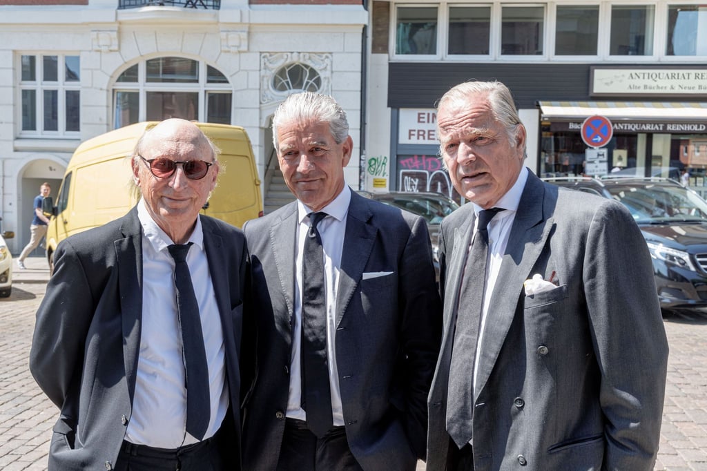 Der Komiker Otto Waalkes (l-r), Christian Völkers, Immobilienmakler, und der Gutsbesitzer Enno von Ruffin stehen vor Beginn des Trauergottesdiensts für Bertram Rickmers vor der Hauptkirche St. Michaelis.