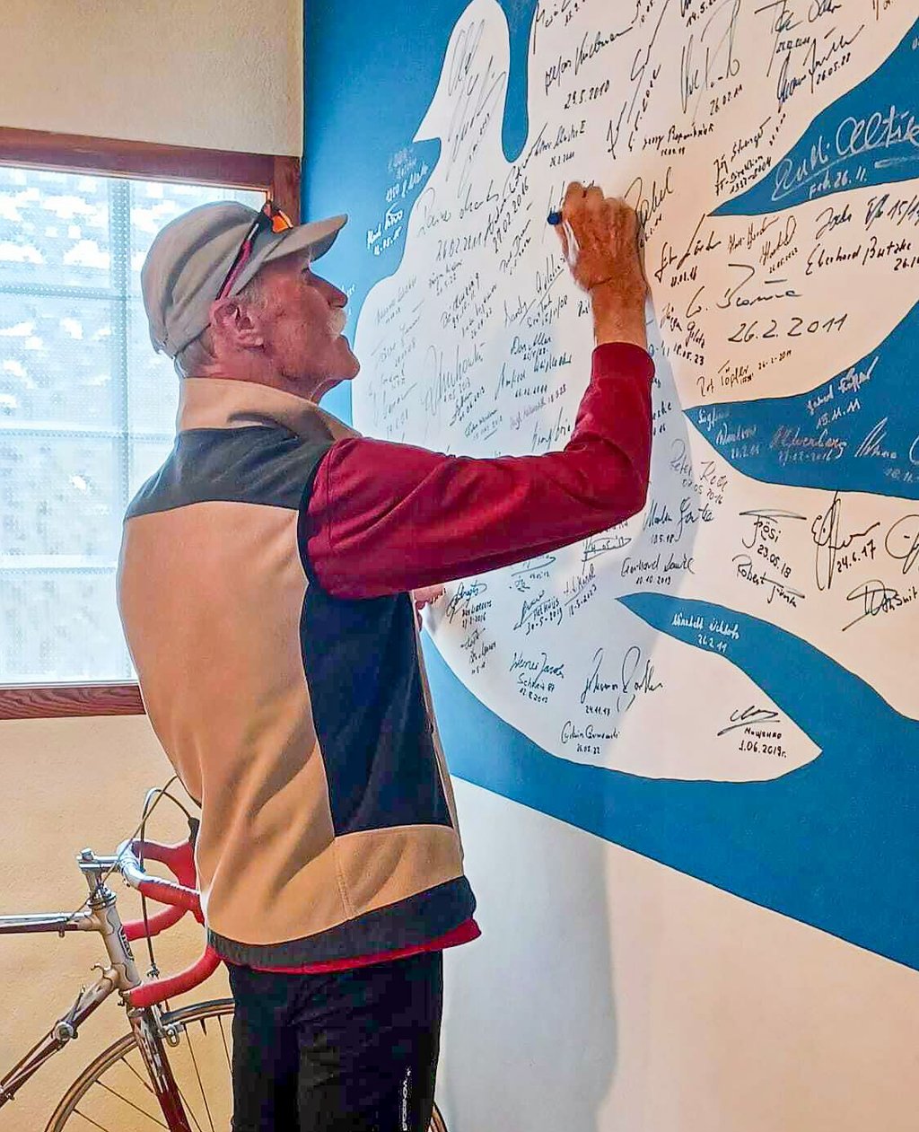 Hans-Joachim Furian beim Signieren auf der Autogrammwand im Friedensfahrtmuseum.