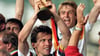 Mannschaftskapitän Lothar Matthäus hält bei der Siegerehrung der Fußball-Weltmeisterschaft am 08.07.1990 im Olympiastadion von Rom triumphierend den WM-Pokal in die Höhe.