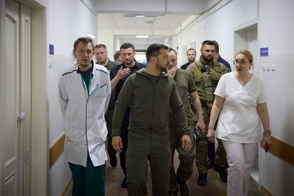 Präsident Selenskyj (M) besucht ein Krankenhaus in dem von den Überschwemmungen betroffenen Gebiet von Cherson.